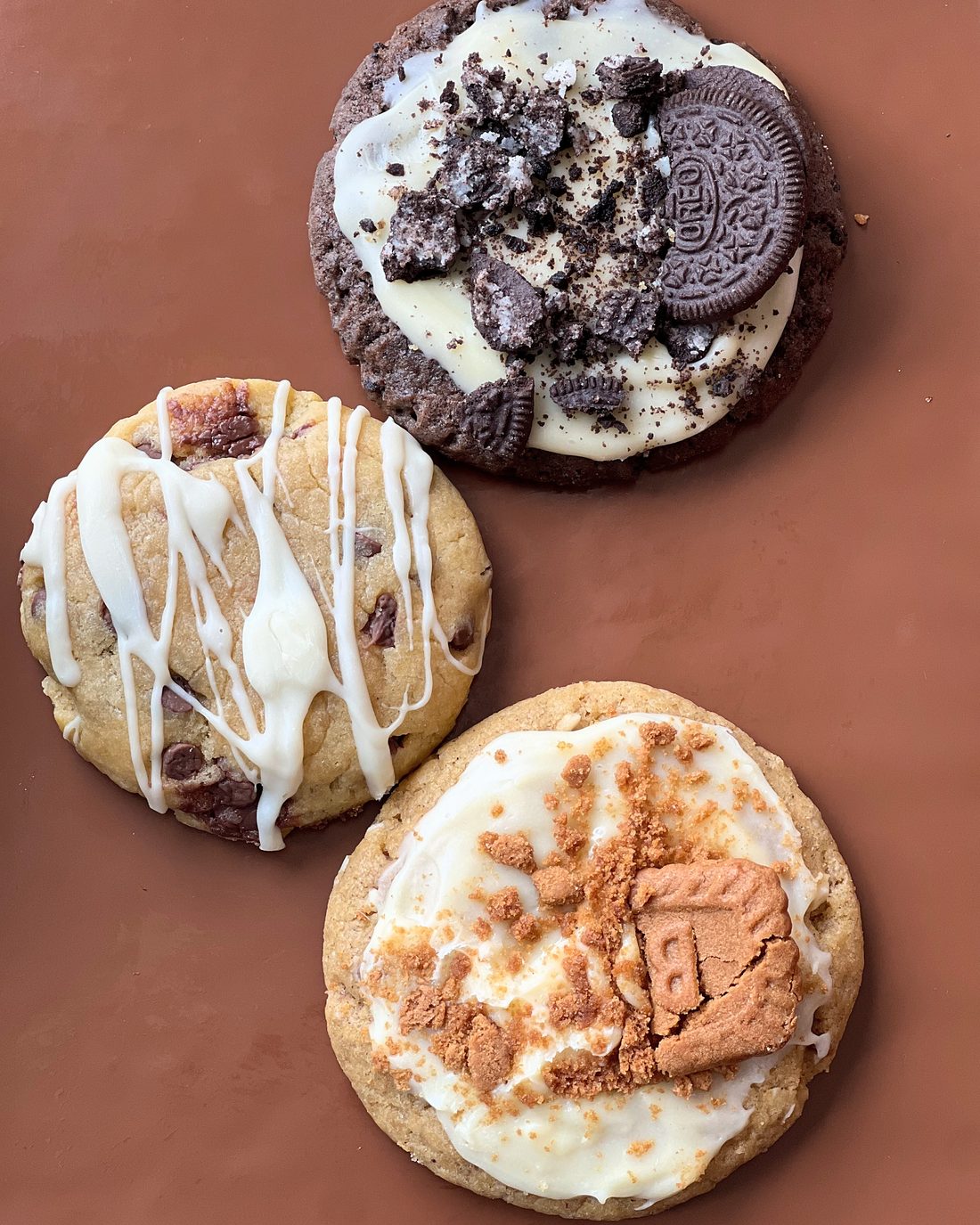 MELT.'s three cookies on brown paper: Oreo & Cream, Hazelnut Choc Chip and Biscoff & Cream